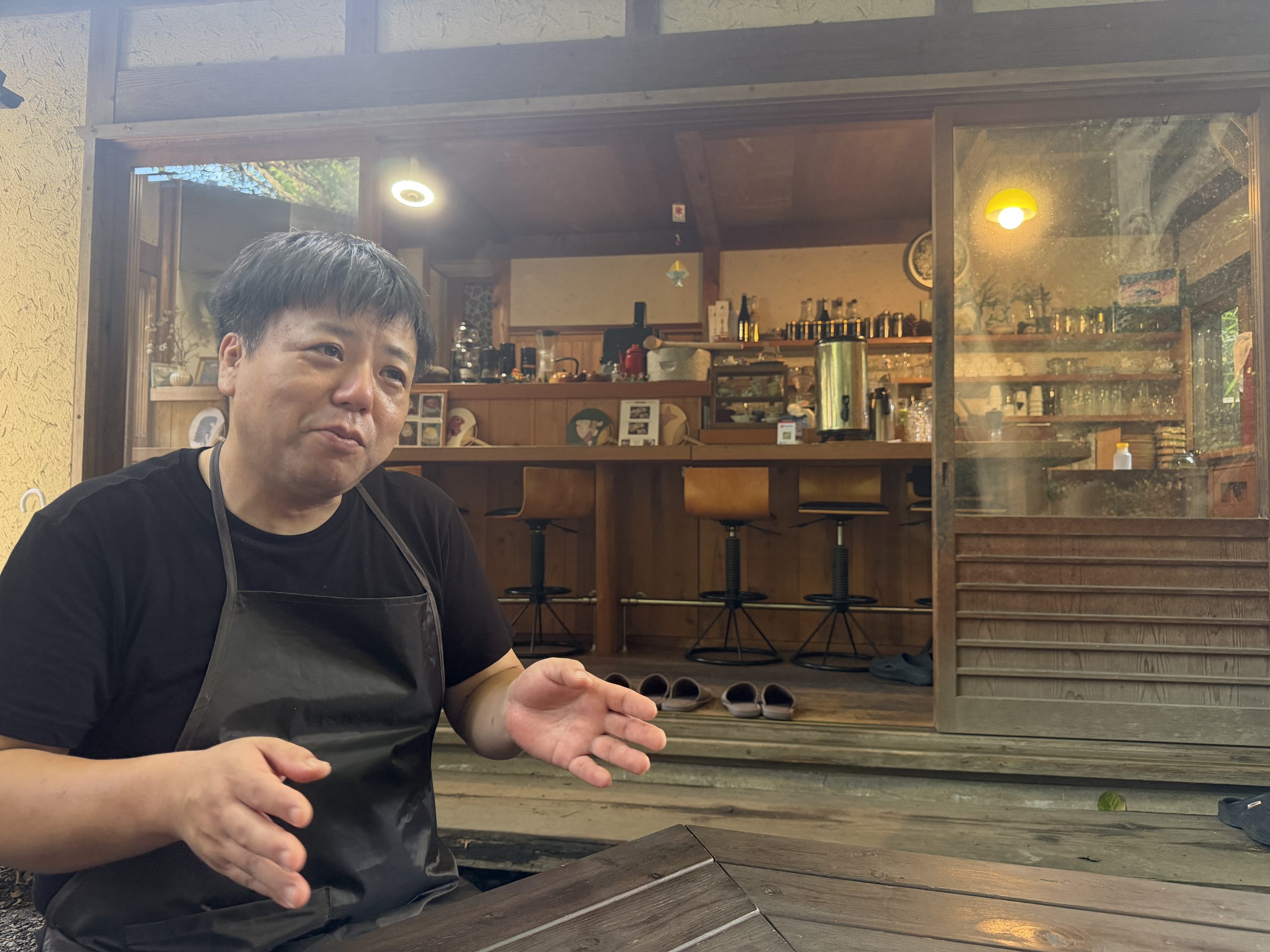 お店の前で、男性が身ぶりを交えて話している様子。