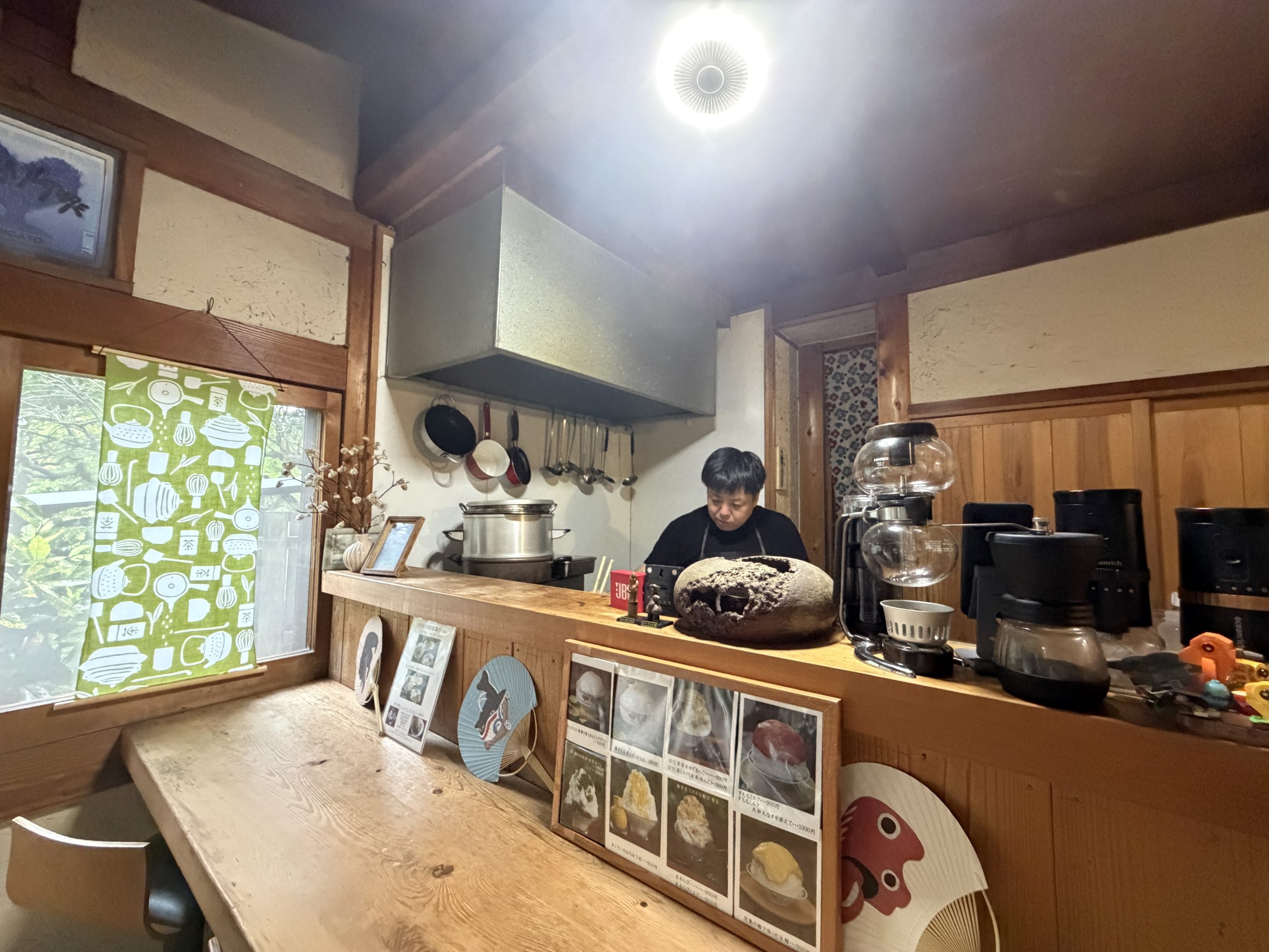 木のカウンターと厨房が見える、落ち着いた古民家風の店内。