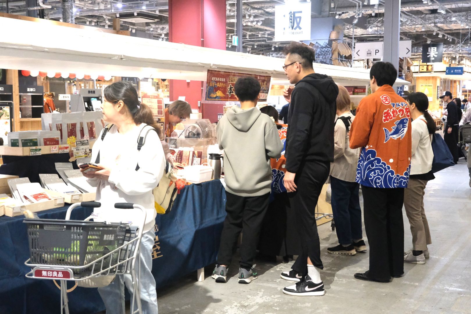 「おだし屋」ブースにお客様が集まり、スタッフがはっぴ姿で接客しているにぎやかな販売風景。